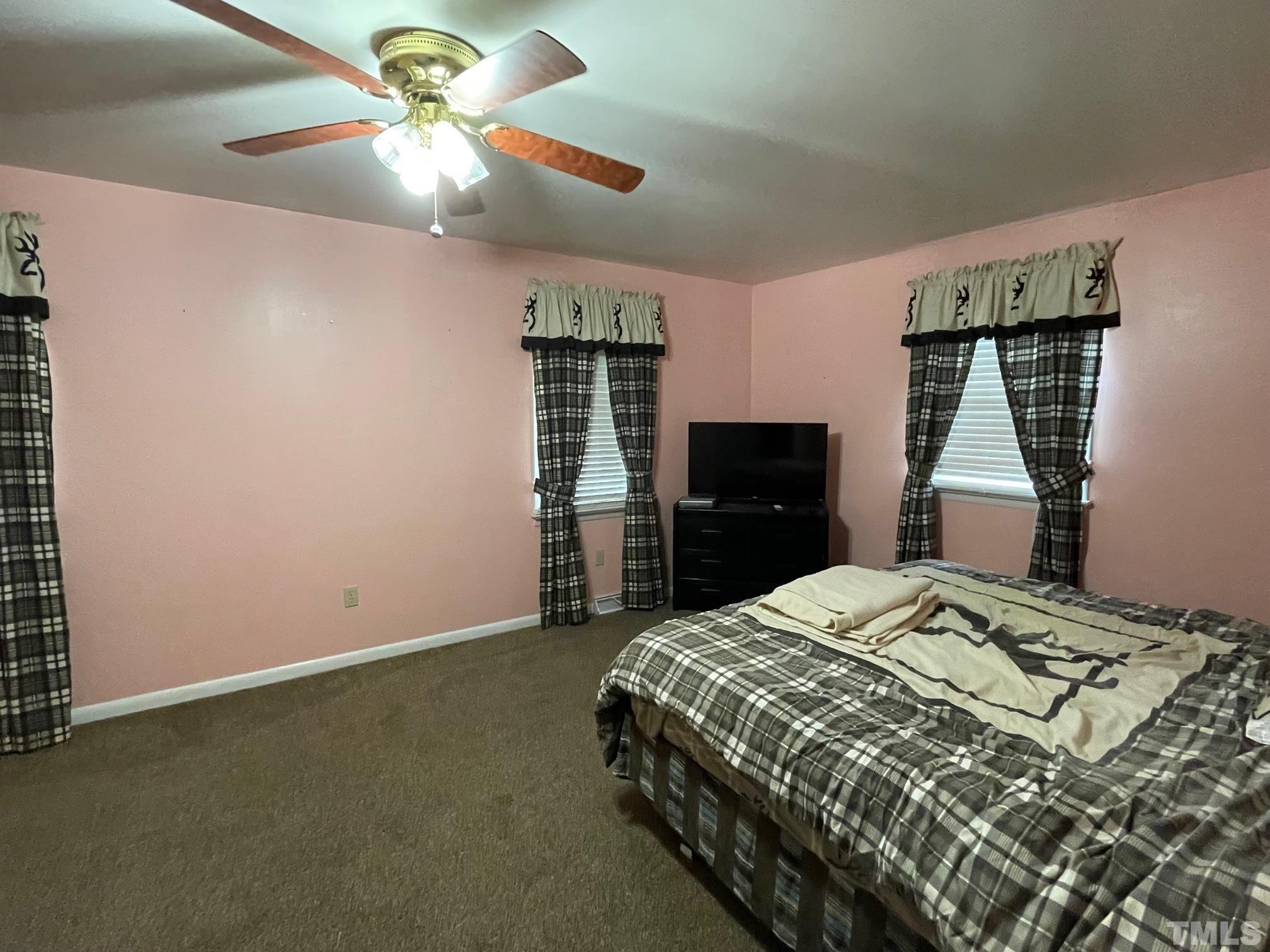 1641 Oak Grove Road Roxboro, NC 27574 - Photo 9 of 23 a bedroom with a bed and a chandelier