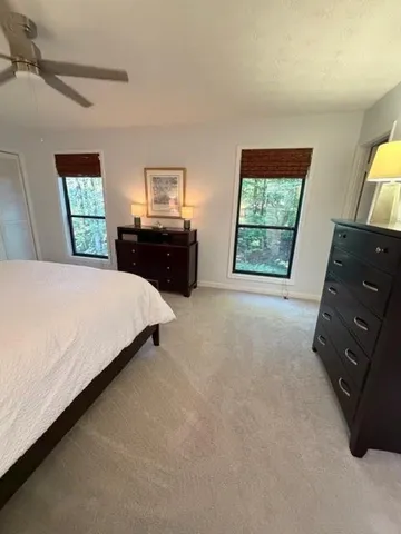 a bedroom with a bed and a flat tv screen on dresser