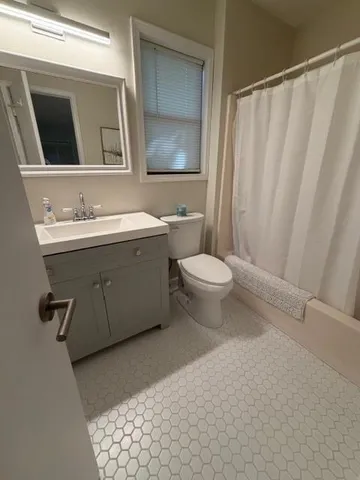 a bathroom with a toilet a sink and mirror