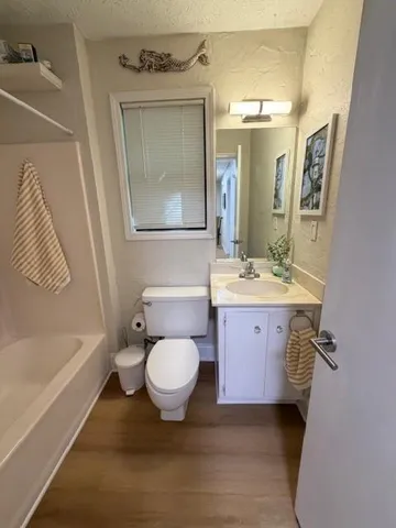 a bathroom with a sink toilet a mirror and bathtub