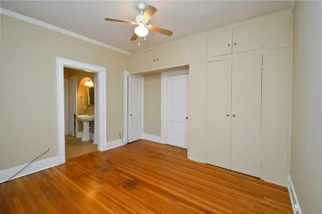 a view of a room with wooden floor and ceiling fan