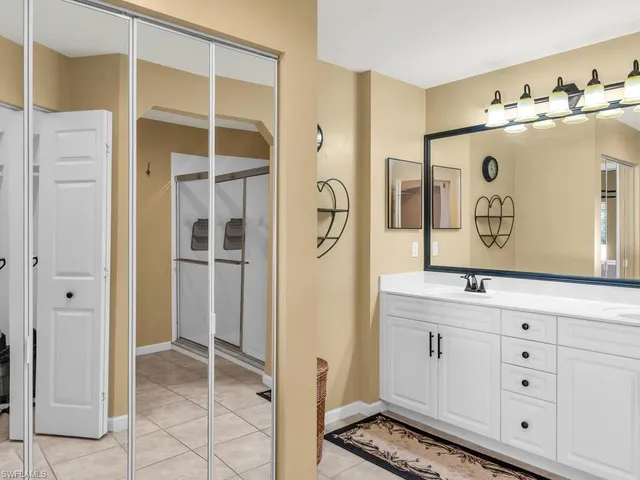 a spacious bathroom with a double vanity sink a mirror and a shower