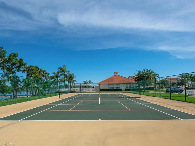 a view of a tennis ground with large trees