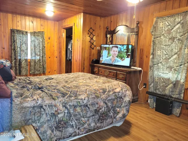 a bed sitting in a spacious bedroom next to a window