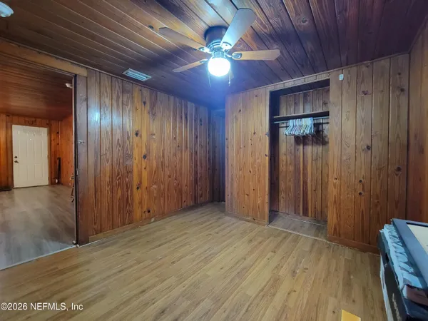 a view of empty room with wooden floor