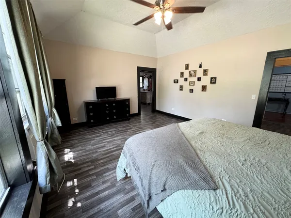 a bedroom with a bed and a flat tv screen on a dresser