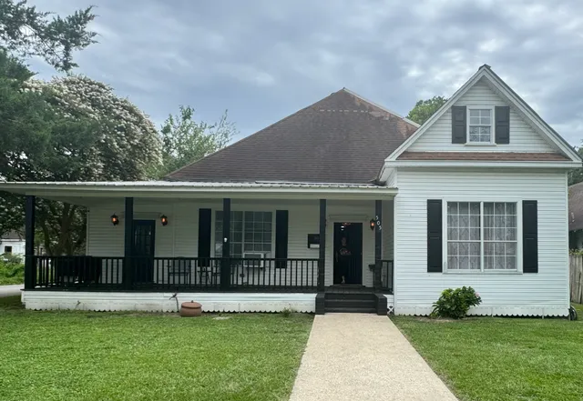 a view of house with yard and glass windows