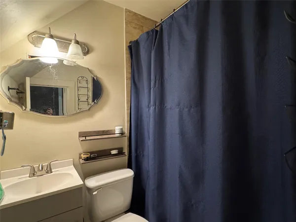 a bathroom with a toilet a sink and mirror