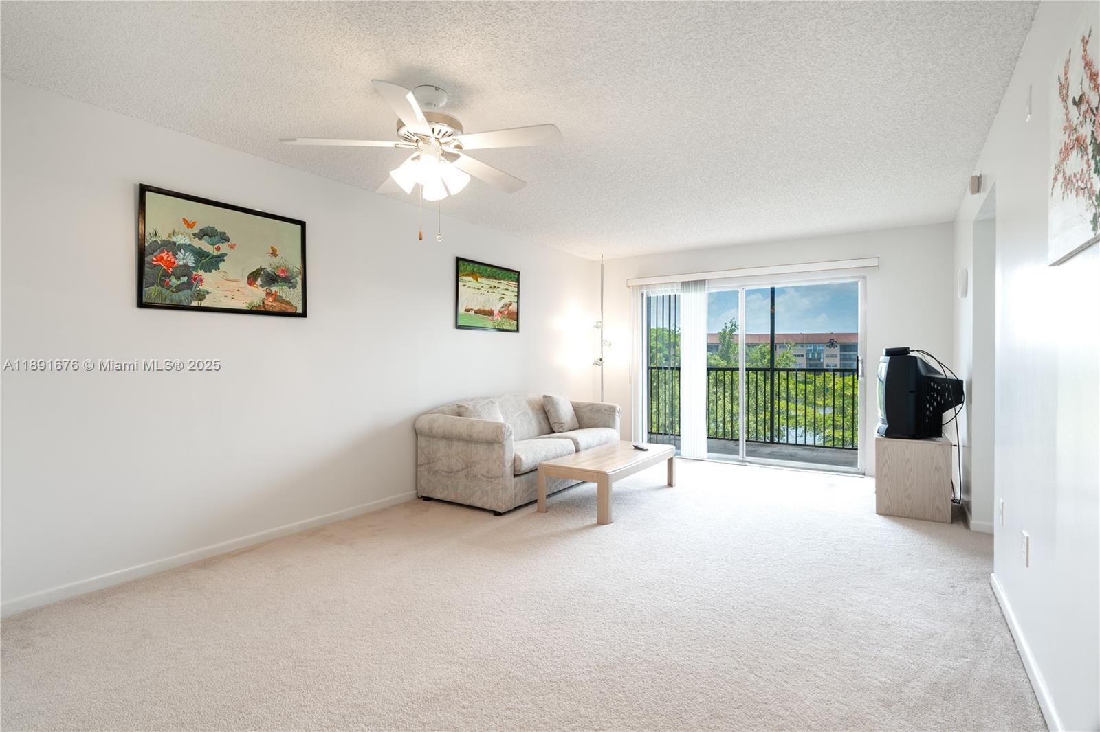13700 Southwest 11th Street, Unit 309A Pembroke Pines, FL 33027 - Photo 14 of 31 a living room with furniture and a large window