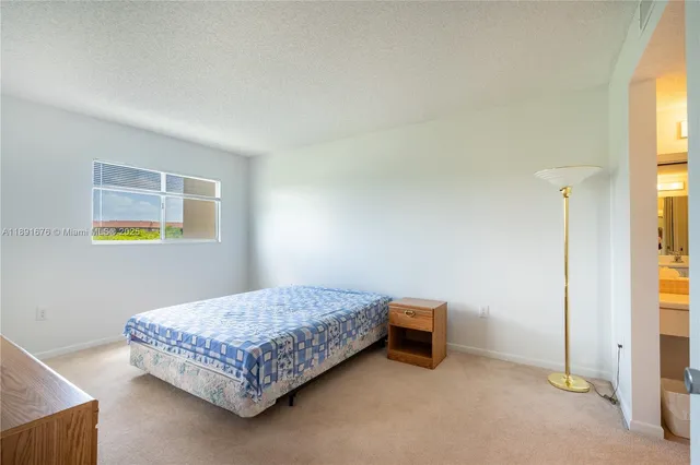 a bedroom with a bed and painting on the wall