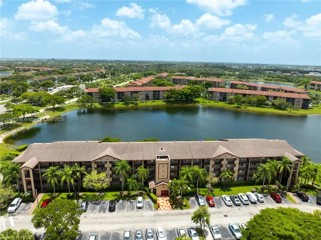 an aerial view of house with yard and lake view in back