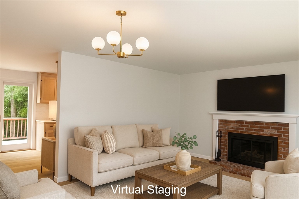 19 Oriole Lane Barnstable, MA 02648 - Photo 2 of 40 a living room with furniture a flat screen tv and a fireplace