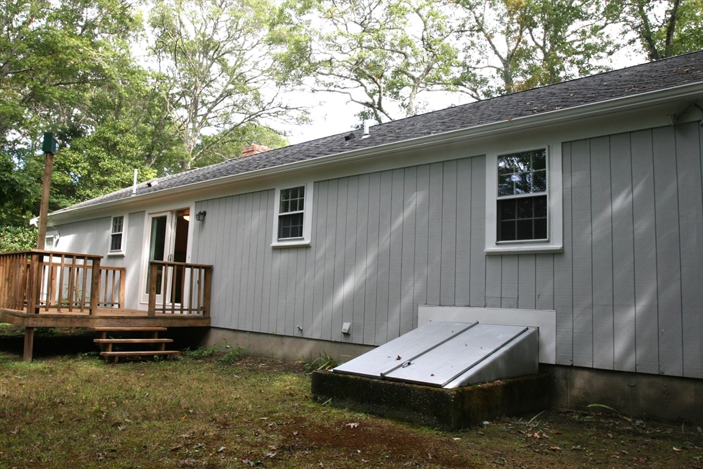 19 Oriole Lane Barnstable, MA 02648 - Photo 39 of 40 a backyard of a house with barbeque oven table and chairs