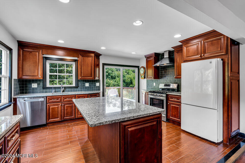 9 Comanche Drive Middletown, NJ 07716 - Photo 20 of 69 a kitchen with granite countertop stainless steel appliances a refrigerator a stove top oven and sink