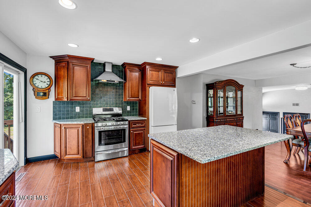 9 Comanche Drive Middletown, NJ 07716 - Photo 22 of 69 a kitchen with stainless steel appliances granite countertop a stove and a wooden floors