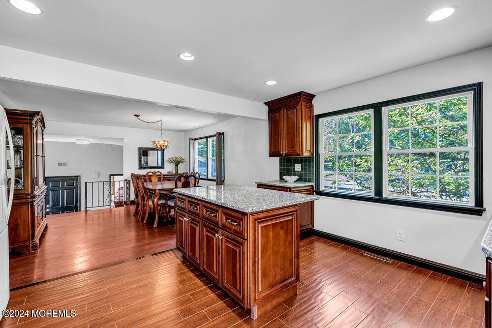 9 Comanche Drive Middletown, NJ 07716 - Photo 23 of 69 a open kitchen with stainless steel appliances granite countertop a stove top oven a dining table and chairs with wooden floor
