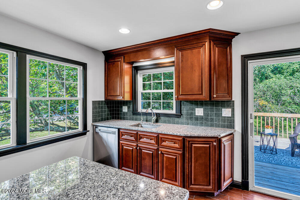 9 Comanche Drive Middletown, NJ 07716 - Photo 24 of 69 a kitchen with stainless steel appliances granite countertop a stove a sink and a wooden cabinets