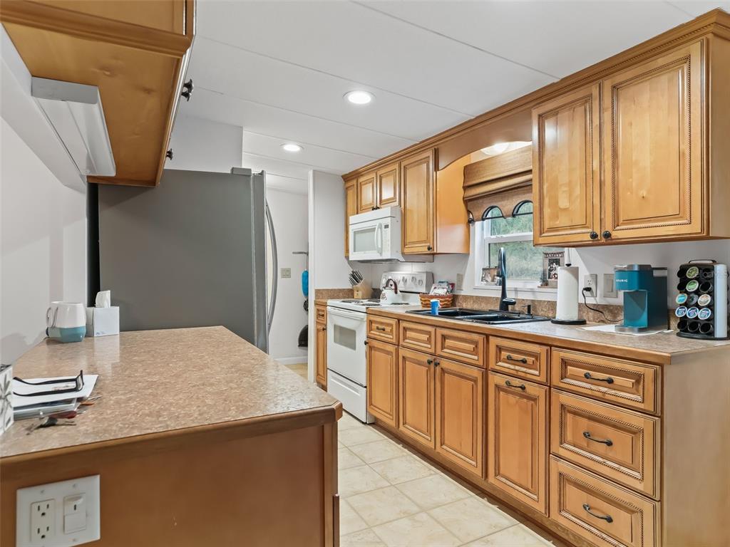 16160 Southeast 97th Terrace Road Summerfield, FL 34491 - Photo 12 of 39 a kitchen with kitchen island granite countertop a sink appliances cabinets and a counter top space