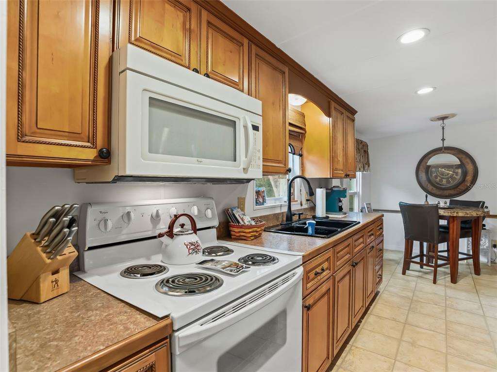 16160 Southeast 97th Terrace Road Summerfield, FL 34491 - Photo 14 of 39 a kitchen with stainless steel appliances granite countertop a stove a sink and a microwave