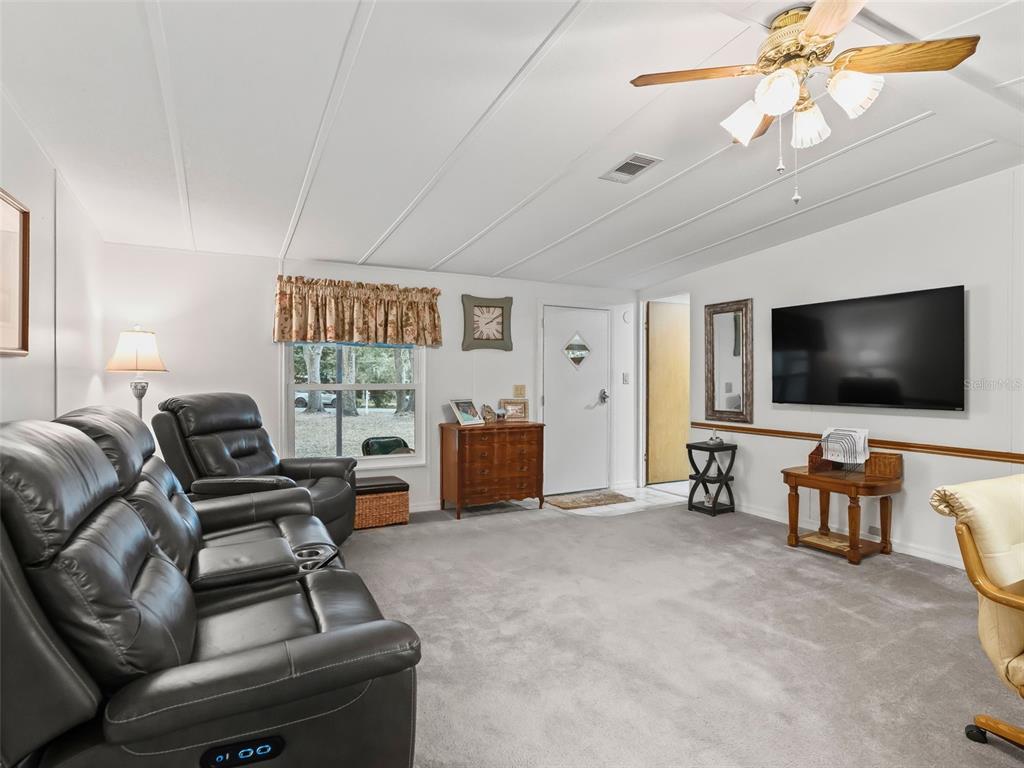 16160 Southeast 97th Terrace Road Summerfield, FL 34491 - Photo 8 of 39 a living room with furniture and a flat screen tv