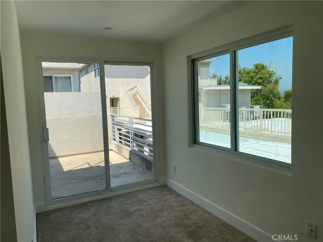 a view of backyard with a table and chairs under an umbrella