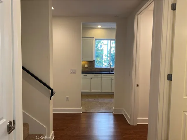 a view of a hallway with wooden floor and stairs