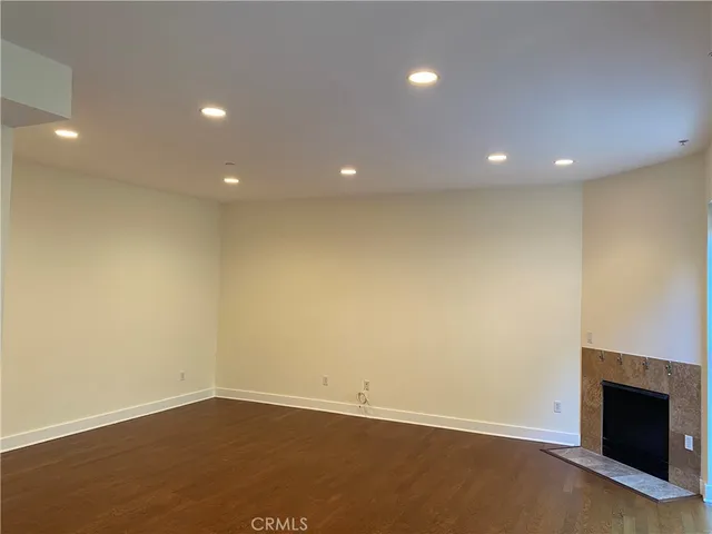 an empty room with wooden floor and fireplace