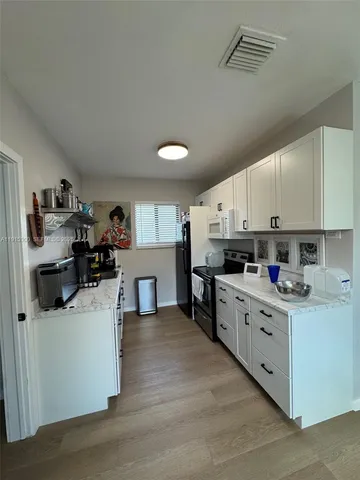 a kitchen with stainless steel appliances a sink a stove top oven a counter space and cabinets