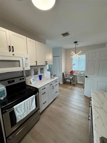 a kitchen with a sink stove and cabinets