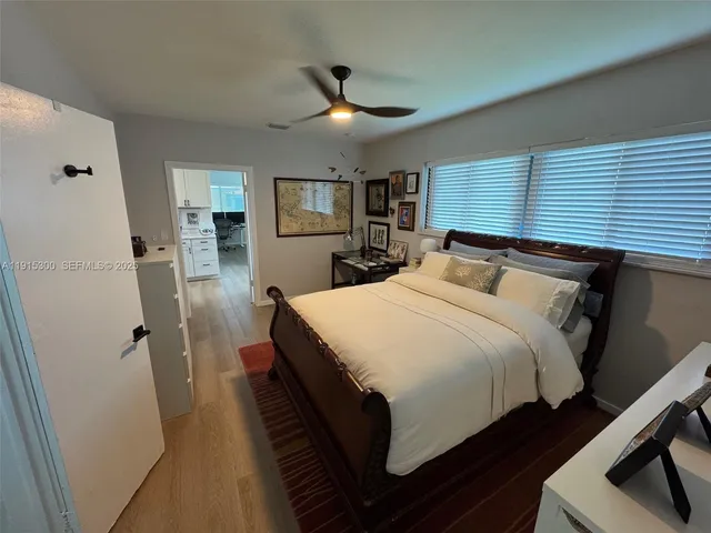 a bedroom with a bed and a flat tv screen on dresser