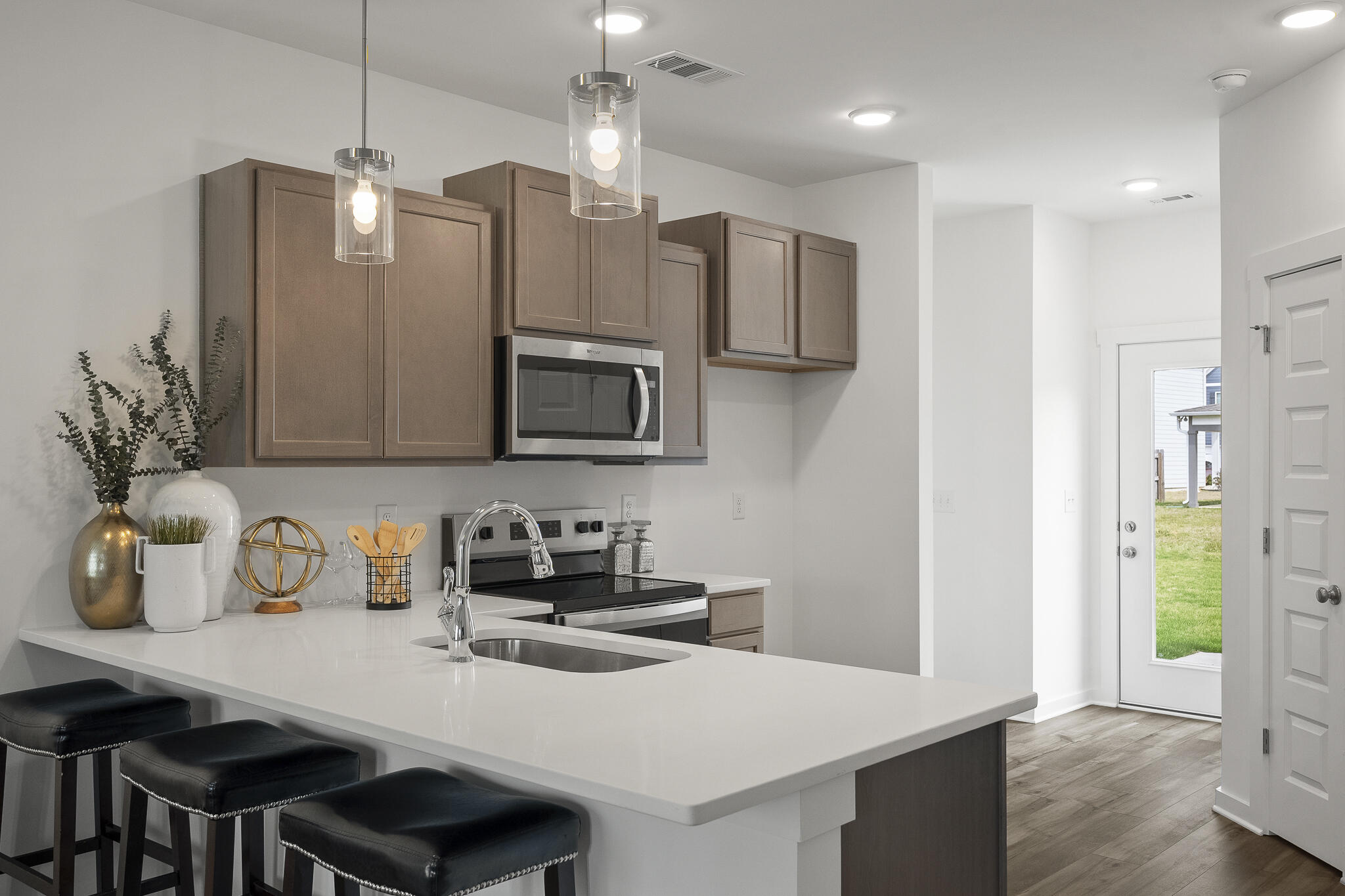 Lot 38 Sweethorn Street DeFuniak Springs, FL 32435 - Photo 9 of 29 a kitchen with stainless steel appliances a sink a refrigerator a microwave a stove and white cabinets