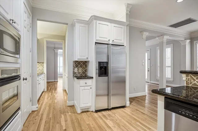 a kitchen with granite countertop white cabinets and appliances
