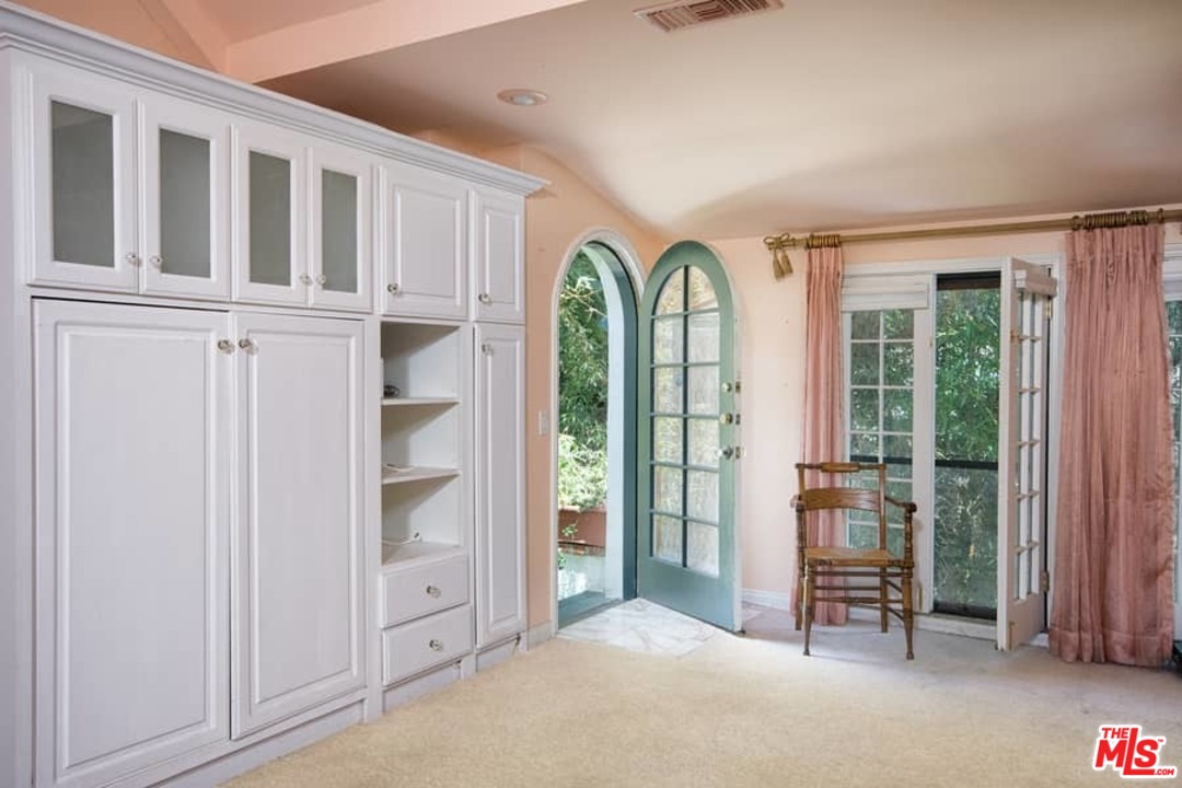 613 North Arden Drive Beverly Hills, CA 90210 - Photo 14 of 25 an empty room with windows closet and chandelier