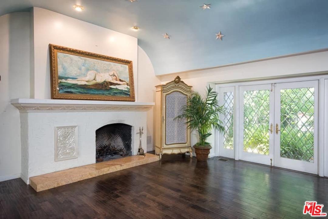 613 North Arden Drive Beverly Hills, CA 90210 - Photo 5 of 25 a view of empty room with floor to ceiling window and fireplace