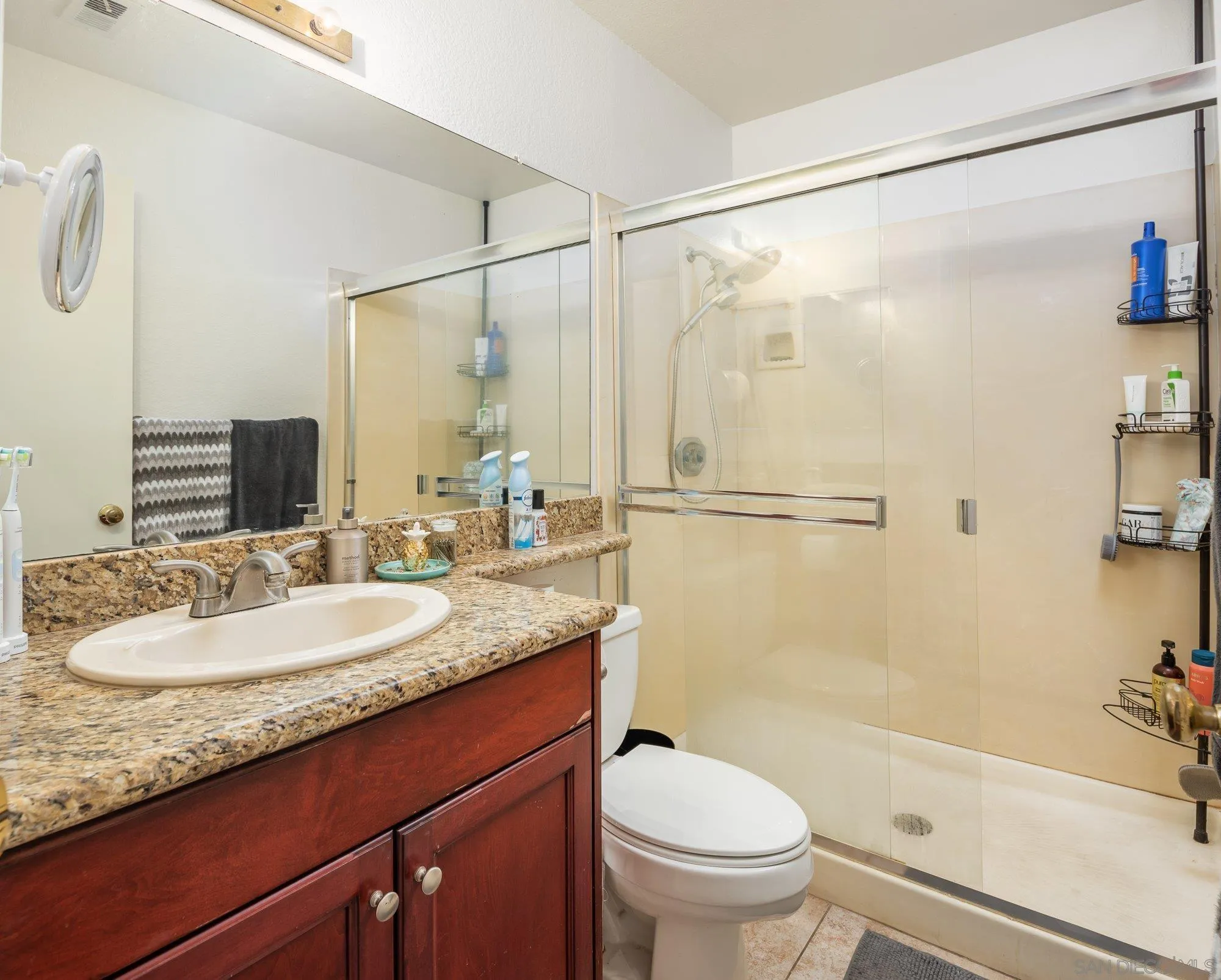 323 Windjammer Circle Chula Vista, CA 91910 - Photo 17 of 27 a bathroom with a granite countertop sink mirror toilet and bathtub