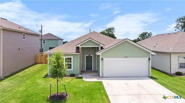a front view of a house with a garden and yard