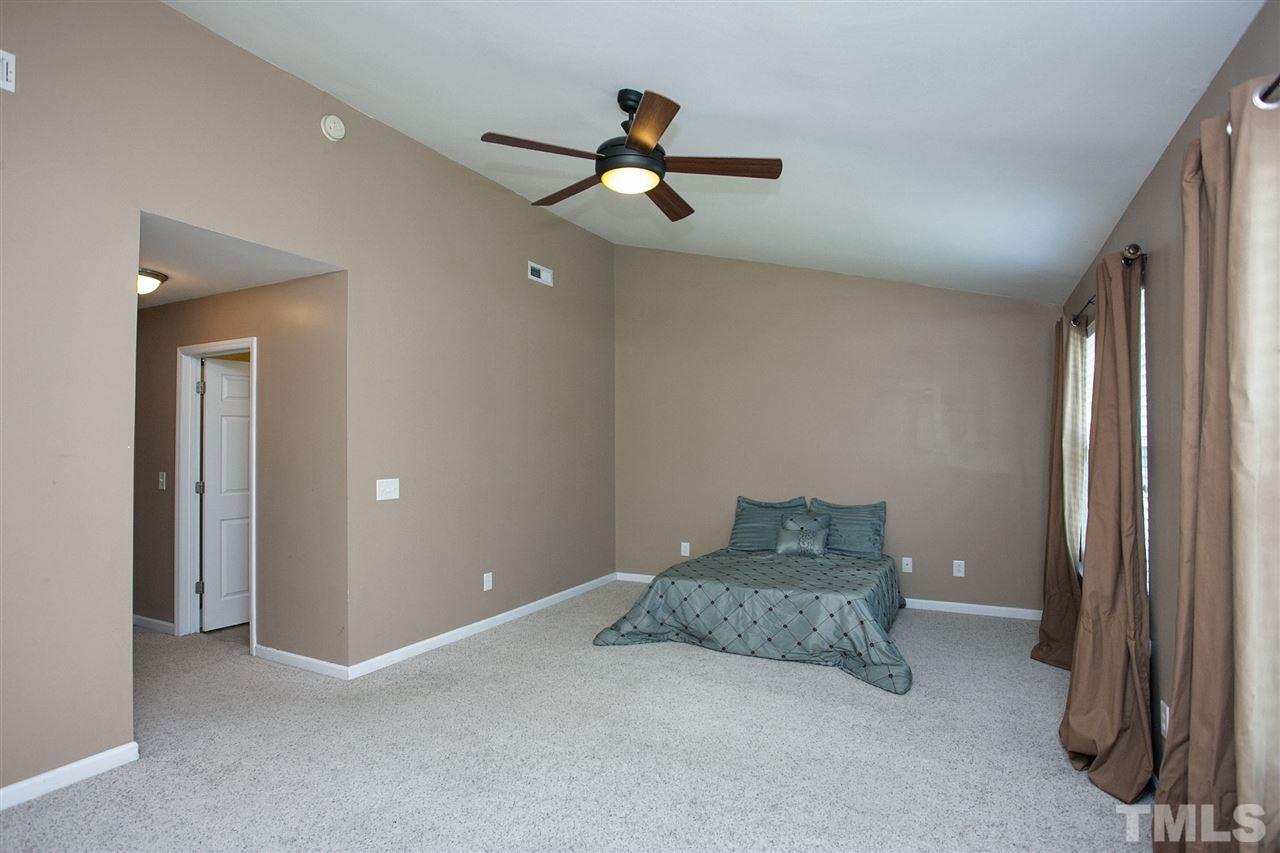 5055 Sandy Banks Road Raleigh, NC 27616 - Photo 13 of 25 a bedroom with a bed and a chandelier fan