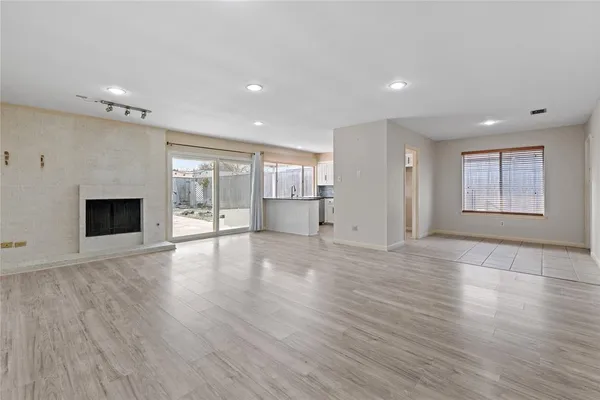 an empty room with wooden floor and fireplace