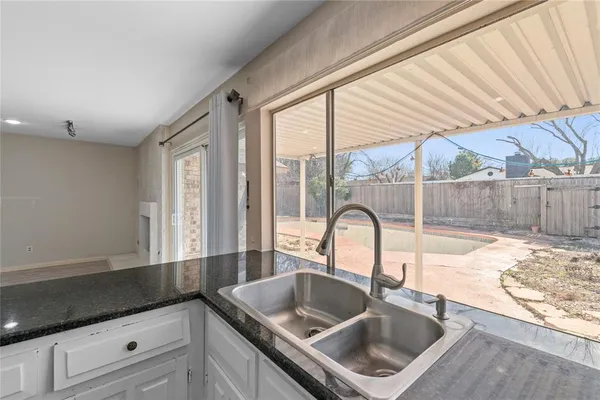 a kitchen with granite countertop a sink and a wooden floor