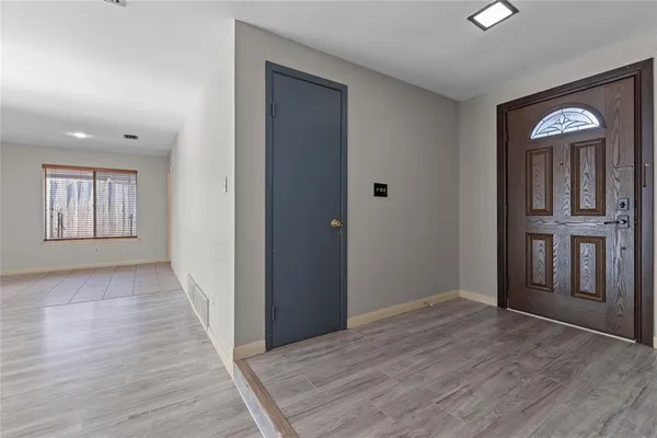 wooden floor in a hall with an entryway and a livingroom