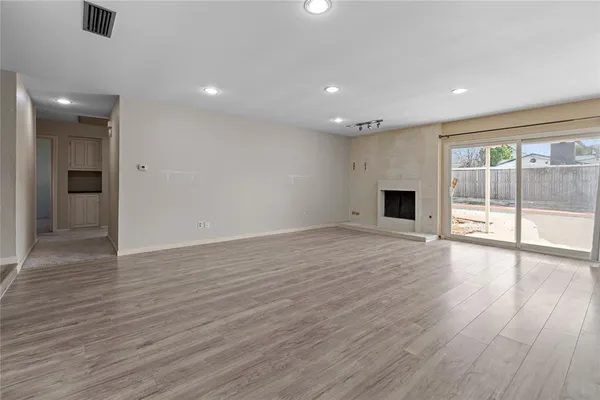 a view of empty room with wooden floor
