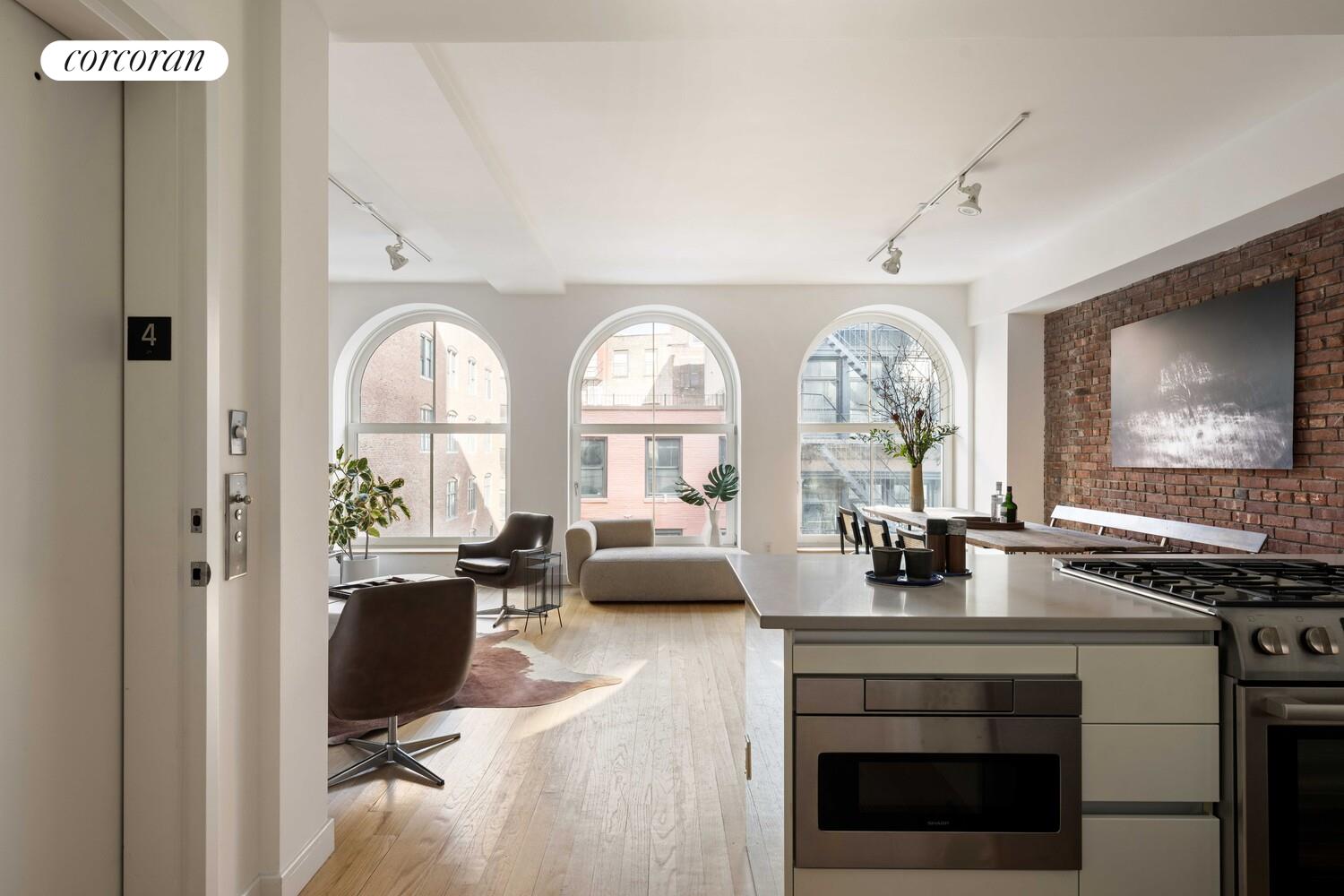 83 Walker Street, Unit 4 Manhattan, NY 10013 - Photo 10 of 21 a living room with fireplace furniture and a large window