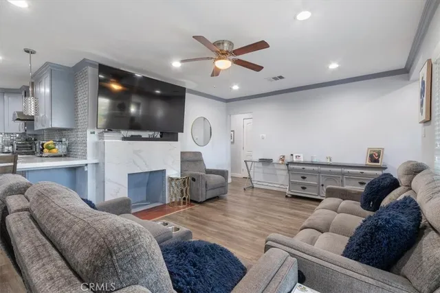 a living room with furniture and a flat screen tv with kitchen view