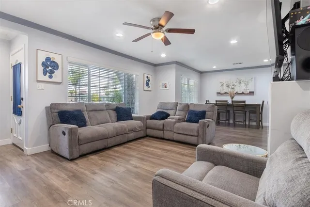 a living room with furniture kitchen view and a chandelier