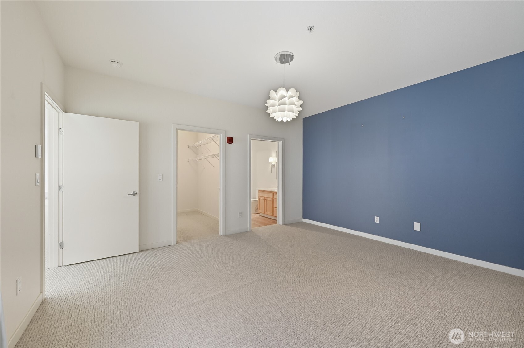 303 23rd Avenue South, Unit 602 Seattle, WA 98144 - Photo 18 of 26 an empty room with chandelier fan and kitchen view