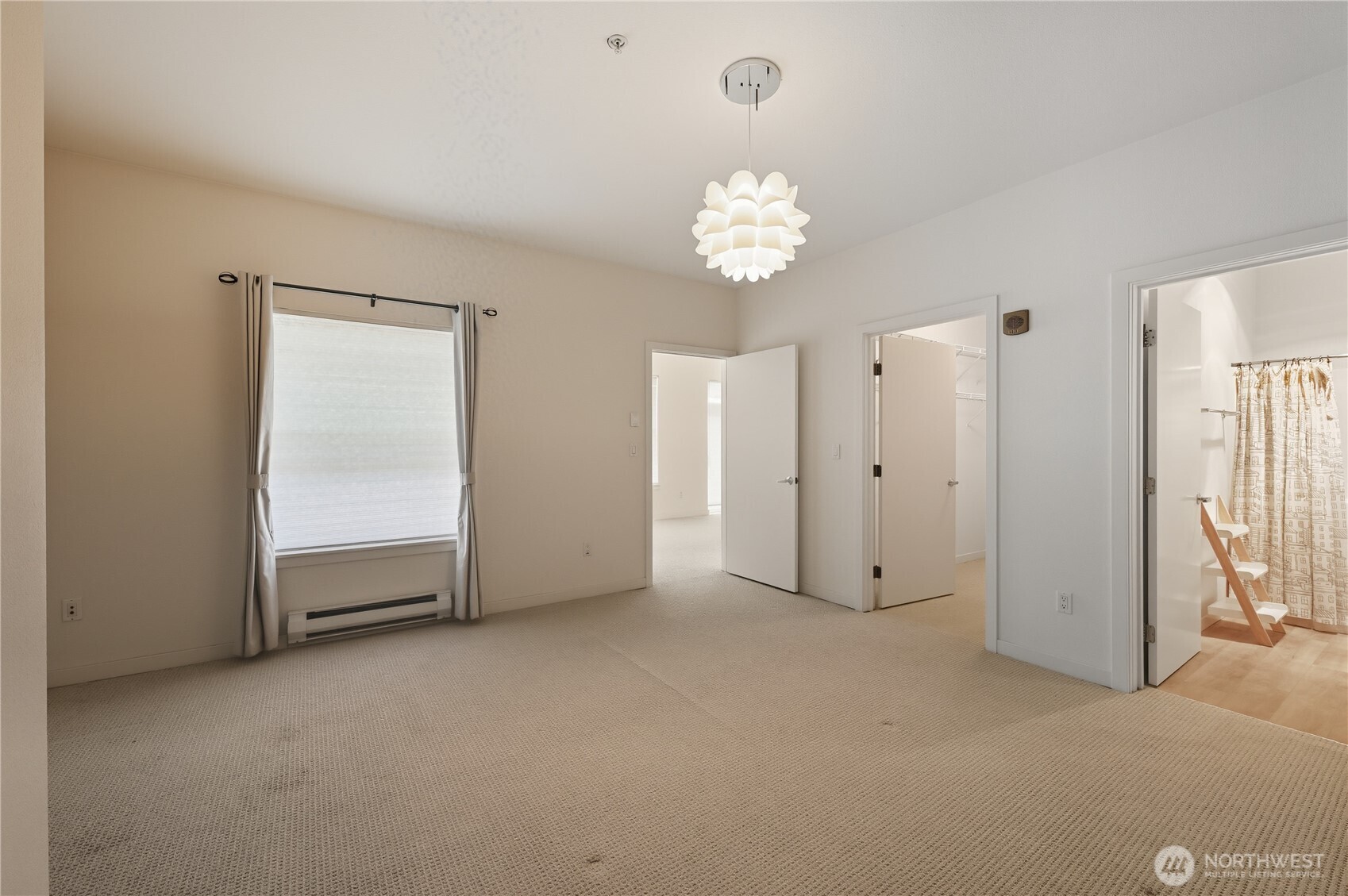 303 23rd Avenue South, Unit 602 Seattle, WA 98144 - Photo 19 of 26 an empty room with a chandelier fan and windows