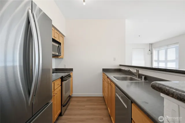 a kitchen with stainless steel appliances granite countertop a sink and a refrigerator