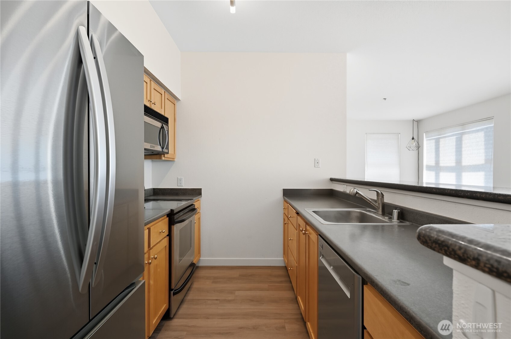303 23rd Avenue South, Unit 602 Seattle, WA 98144 - Photo 10 of 26 a kitchen with stainless steel appliances granite countertop a sink and a refrigerator