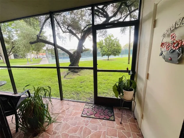 a room with a large window and a potted plant