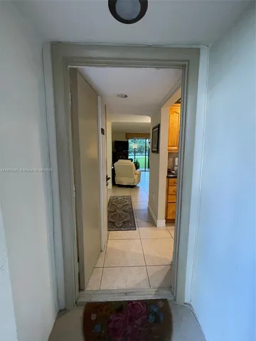 a hallway with a white cabinets and wooden floor